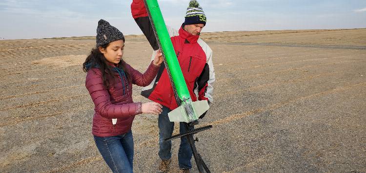 Instructor Will Hamp and club president Trixie Teng ready her rocket for launch.
